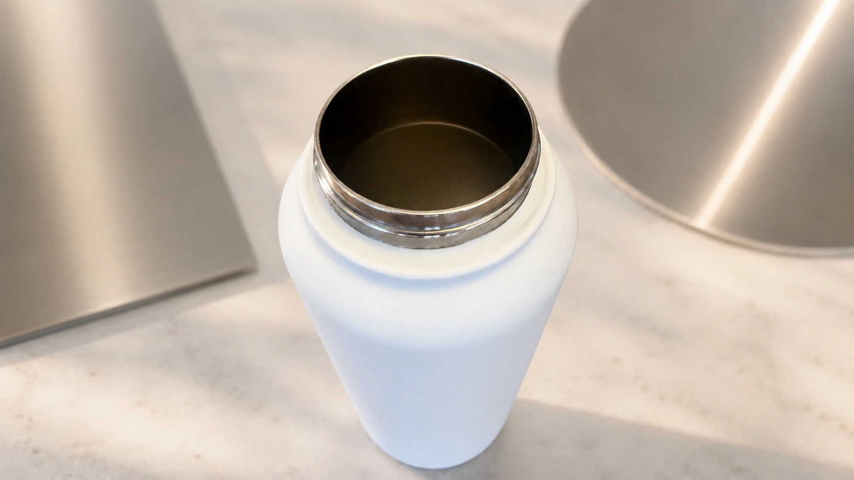 Close-up van witte RVS drinkfles met zichtbare roestvrijstalen binnenkant